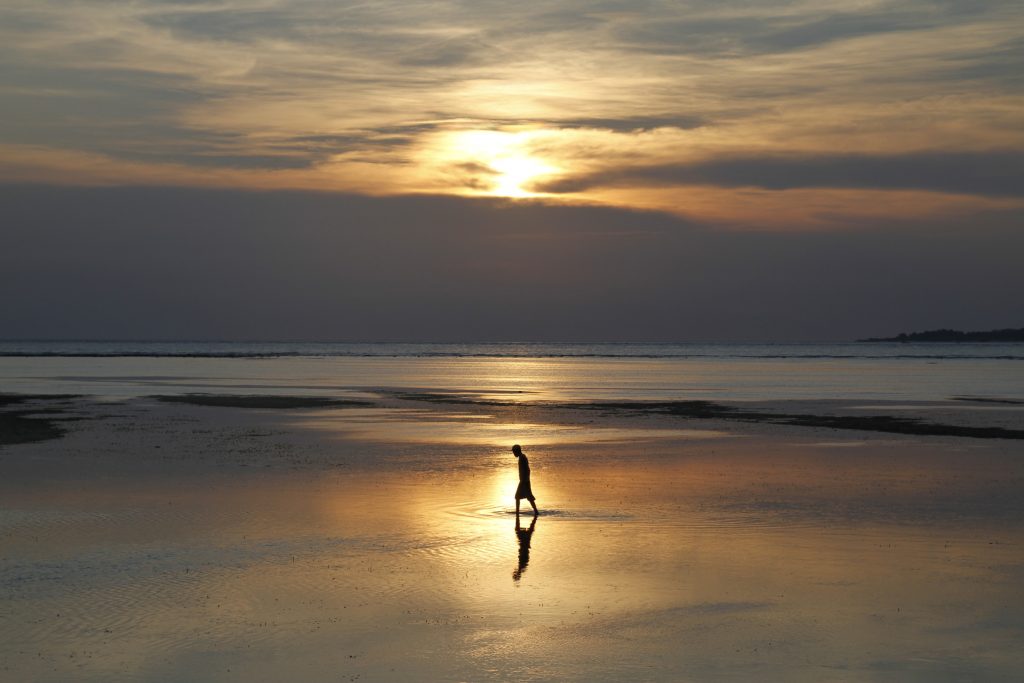 Fisherman walking in the sunset