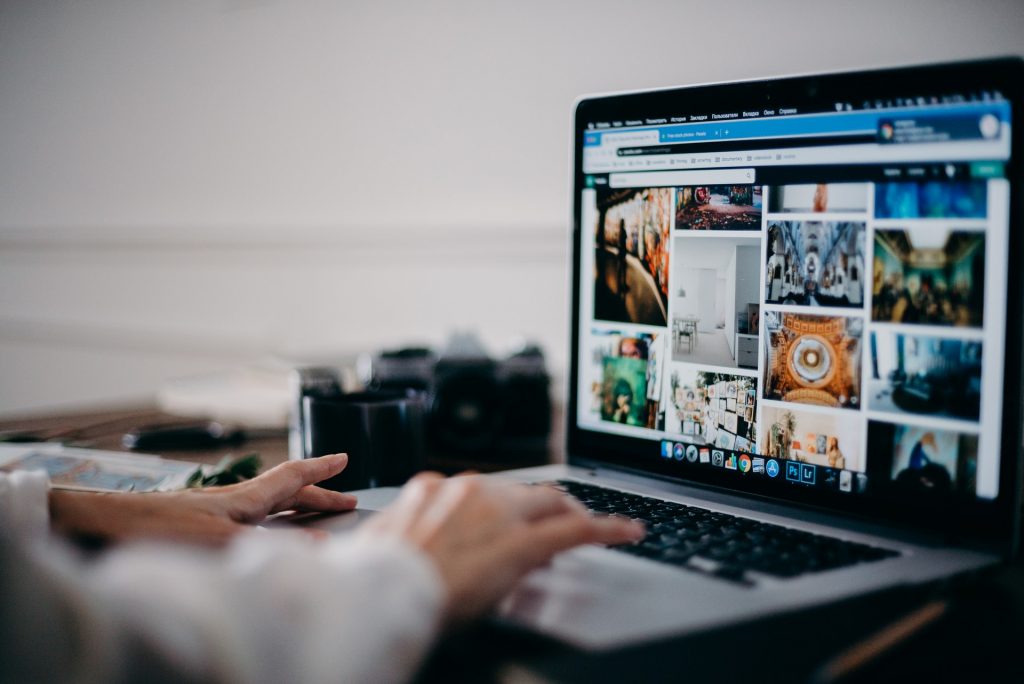 A person on their laptop selecting a photo for their website.